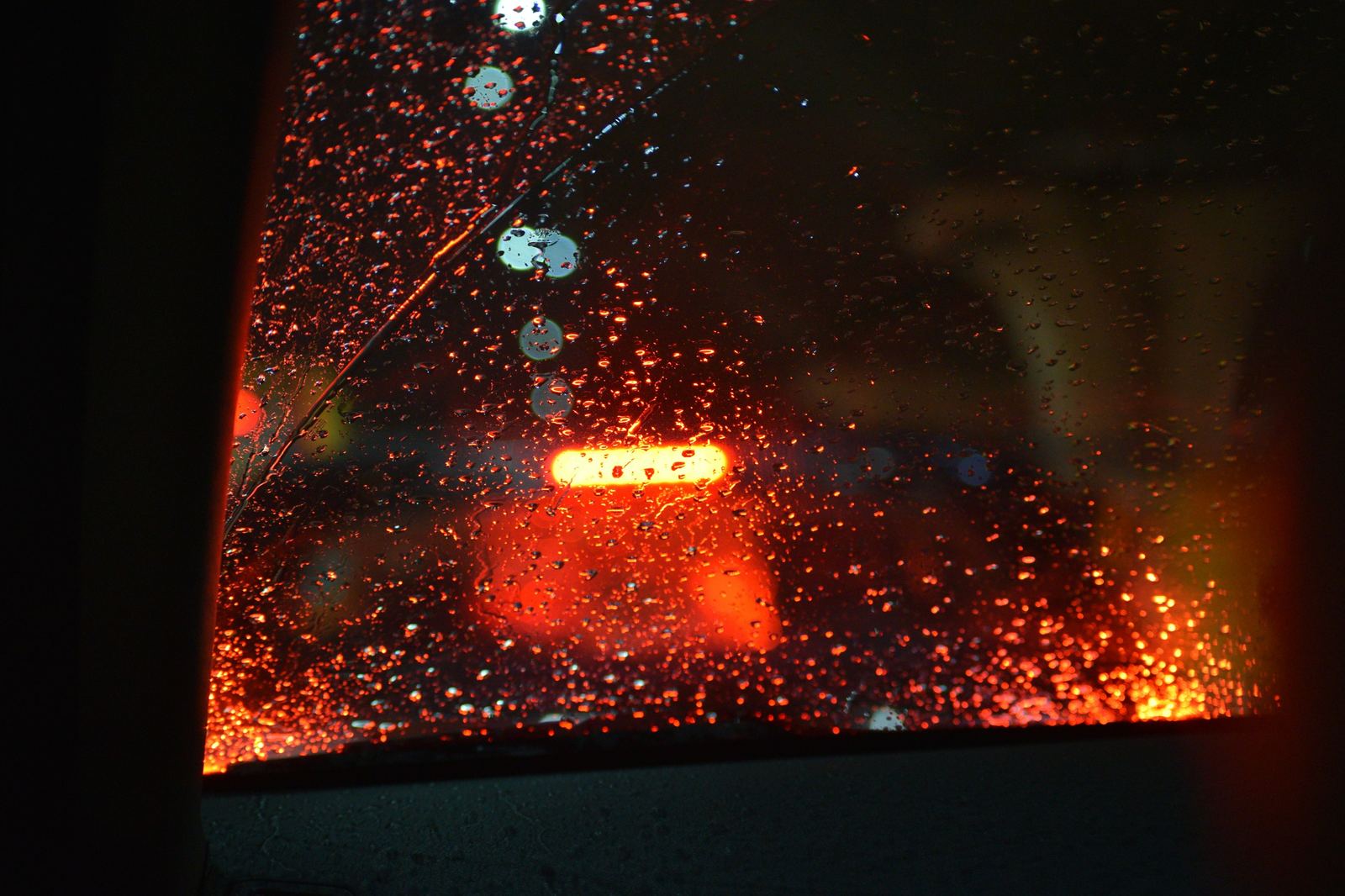 Vista de la calle a través de una ventana con gotas de lluvia.